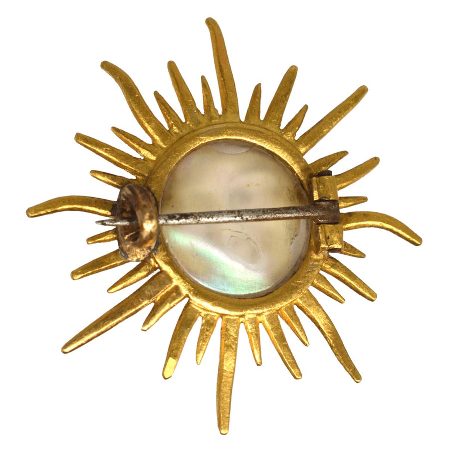 Edwardian 18ct gold sunburst brooch featuring opalescent glass man in the moon, circa 1910s, elegant vintage jewelry.