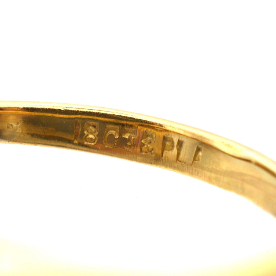 Close-up of hallmark on an 18ct gold and platinum ring, showcasing quality craftsmanship.
