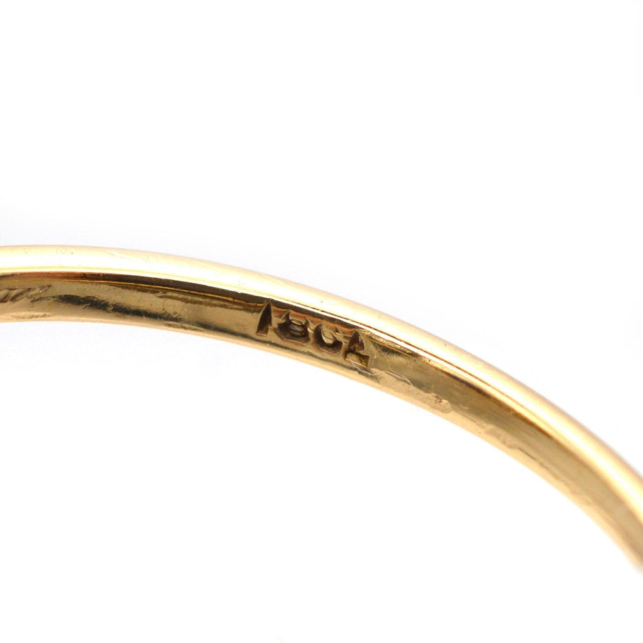 Close-up of the hallmark on an Edwardian 18ct gold ring, showcasing the 1910 era characteristic.
