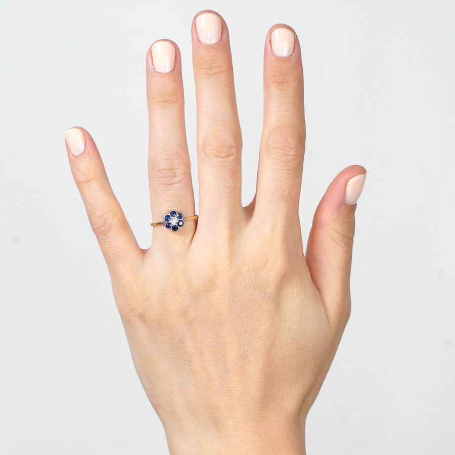 Edwardian 18ct gold and platinum sapphire diamond flower cluster ring worn on hand, showcasing vibrant sapphires.