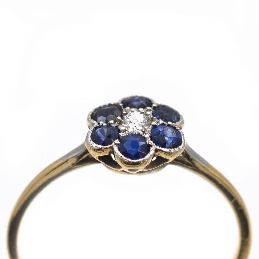 Edwardian 18ct gold and platinum flower cluster ring featuring sapphires and a diamond, circa 1910.