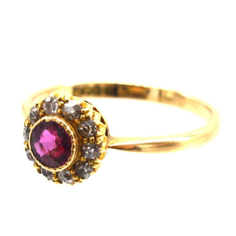 Edwardian 18ct gold ruby and diamond cluster ring, featuring a central ruby surrounded by sparkling diamonds.