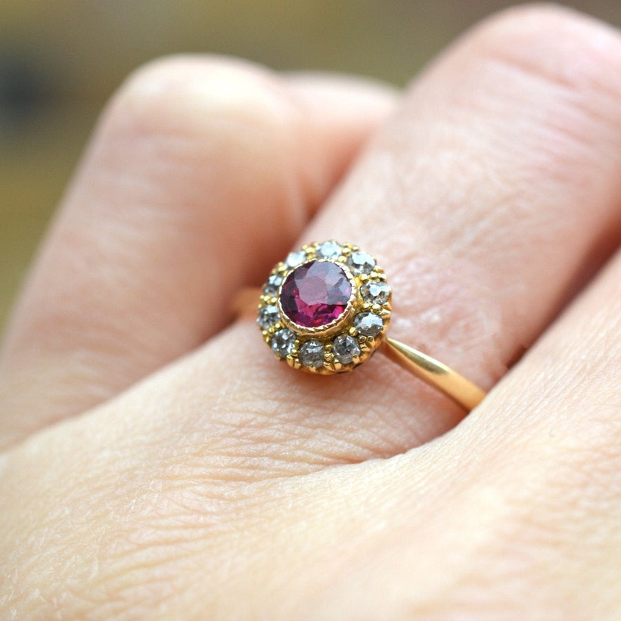 Edwardian 18ct gold ruby and diamond cluster ring, featuring a central ruby surrounded by sparkling diamonds.