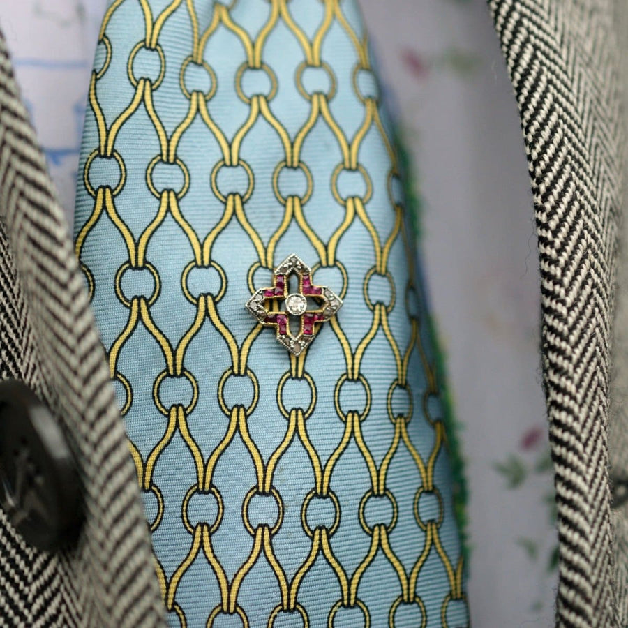Edwardian 18ct gold tie pin with ruby and diamond on blue silk tie, showcasing exquisite craftsmanship.
