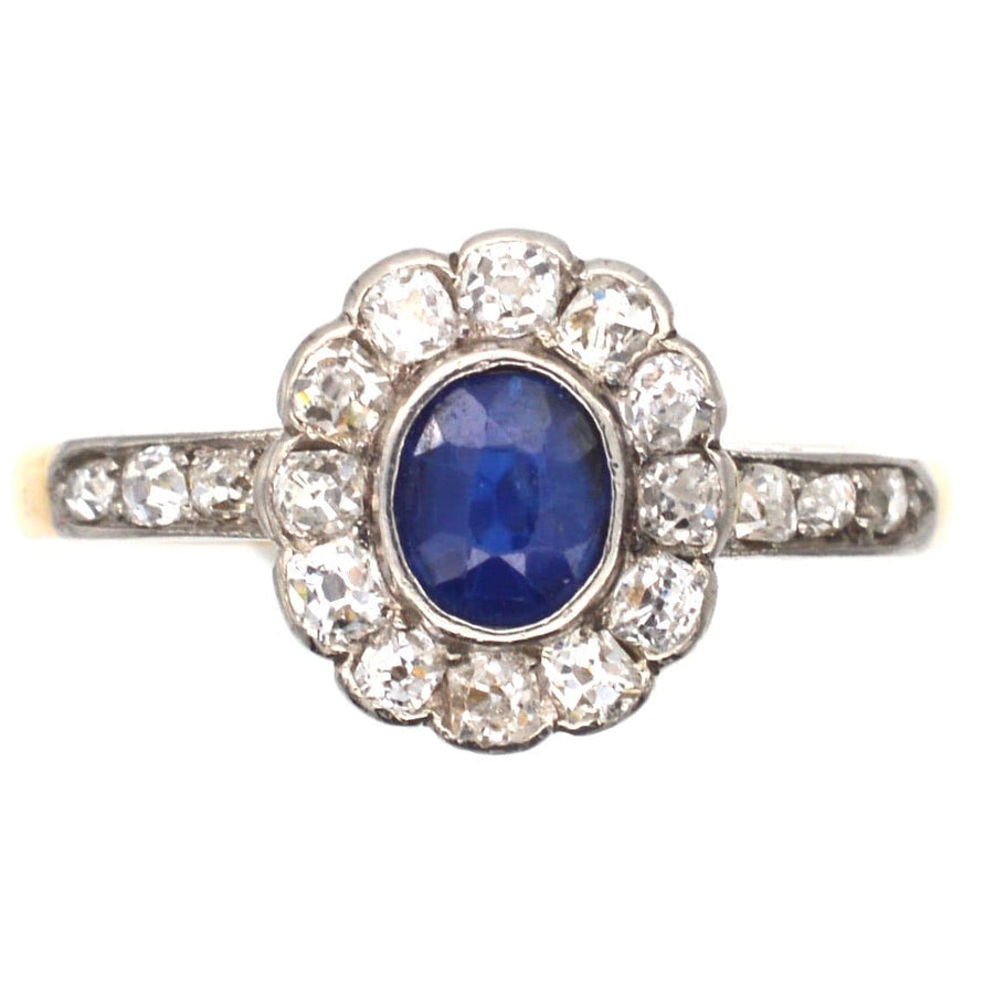 Edwardian 18ct gold cluster ring featuring a blue sapphire center and diamond accents, circa 1910.