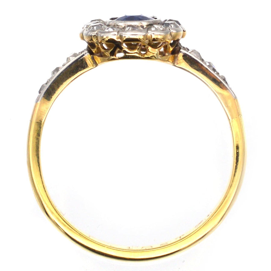 Edwardian 18ct gold sapphire and diamond cluster ring, showcasing side diamond shoulders and a royal blue sapphire.