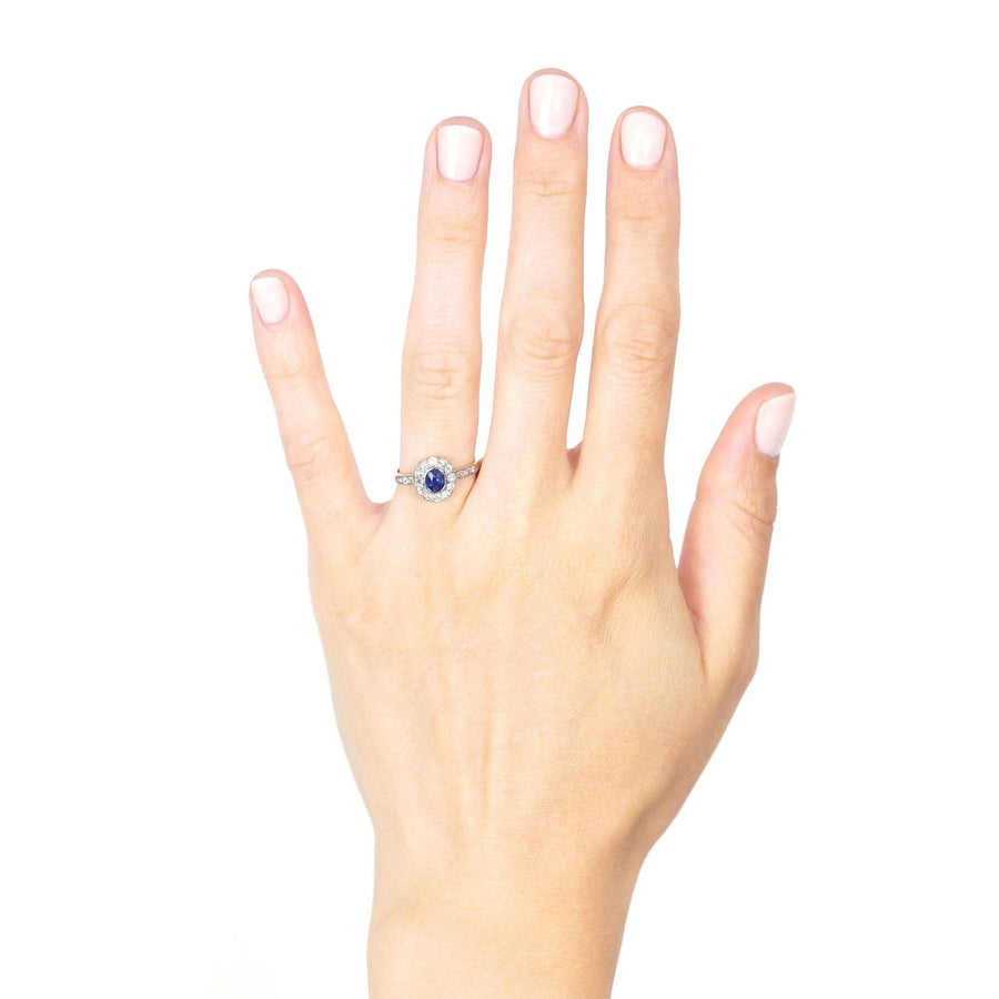 Edwardian 18ct gold sapphire and diamond cluster ring worn on hand, showcasing its royal blue sapphire and sparkling diamond details.