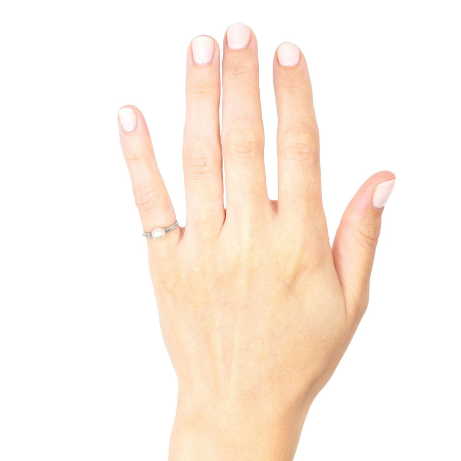 Edwardian 18ct white gold & platinum ring with natural pearl and diamonds displayed on a hand.