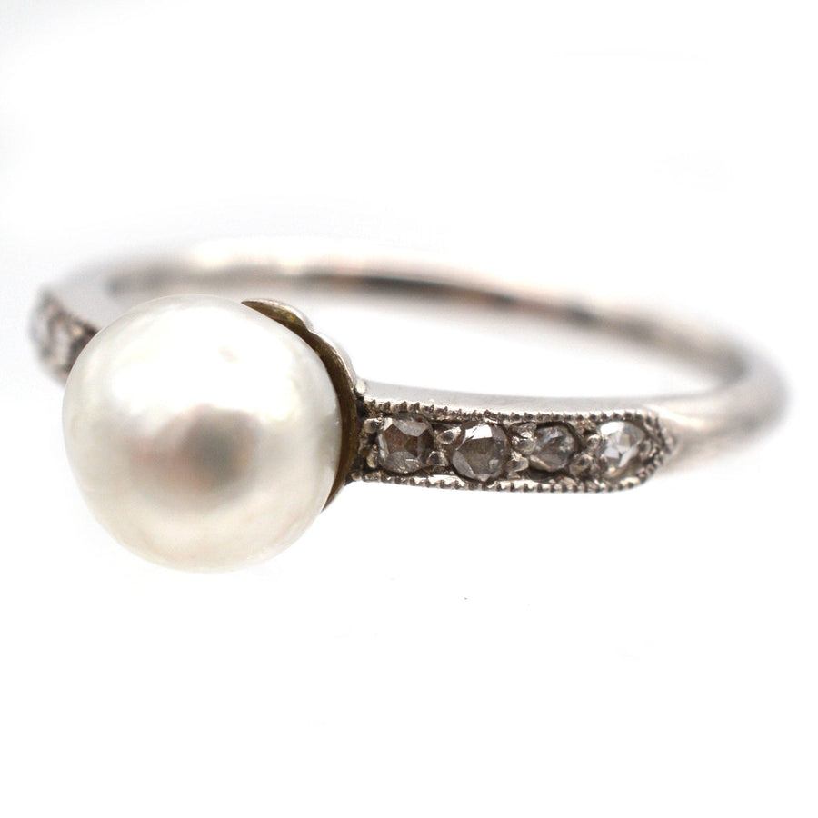 Edwardian 18ct white gold and platinum ring featuring a natural pearl and diamond accents.
