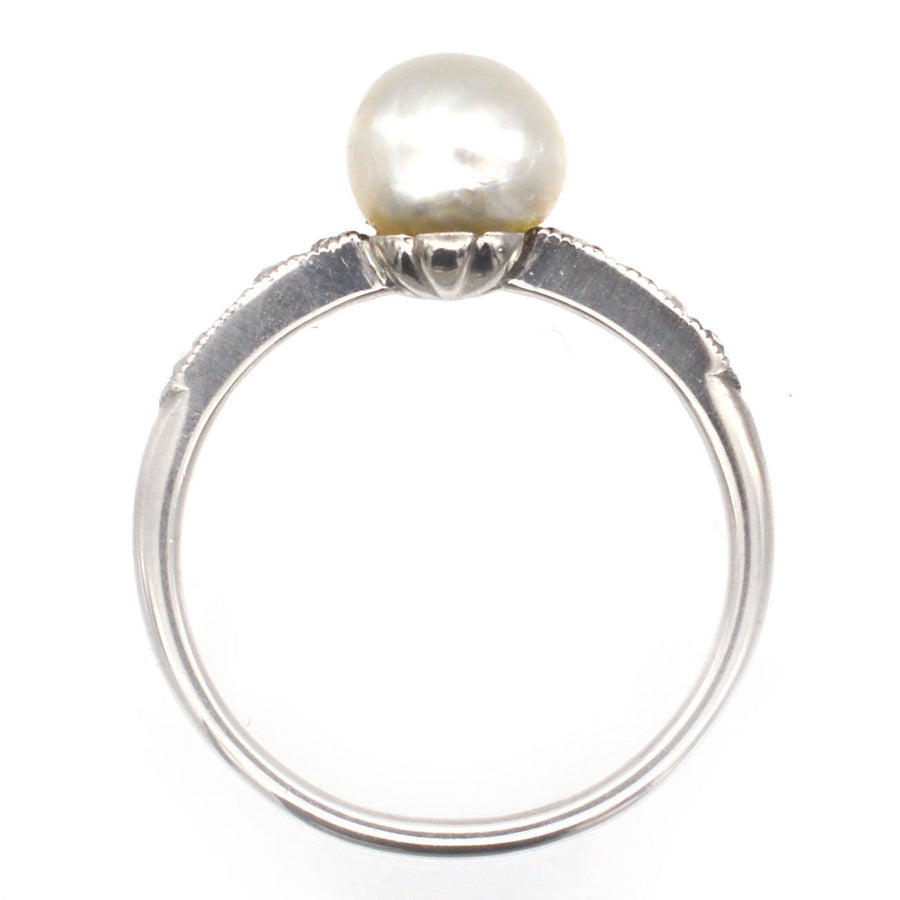 Edwardian 18ct white gold and platinum ring featuring a large natural pearl and diamond shoulders, elegant vintage design.