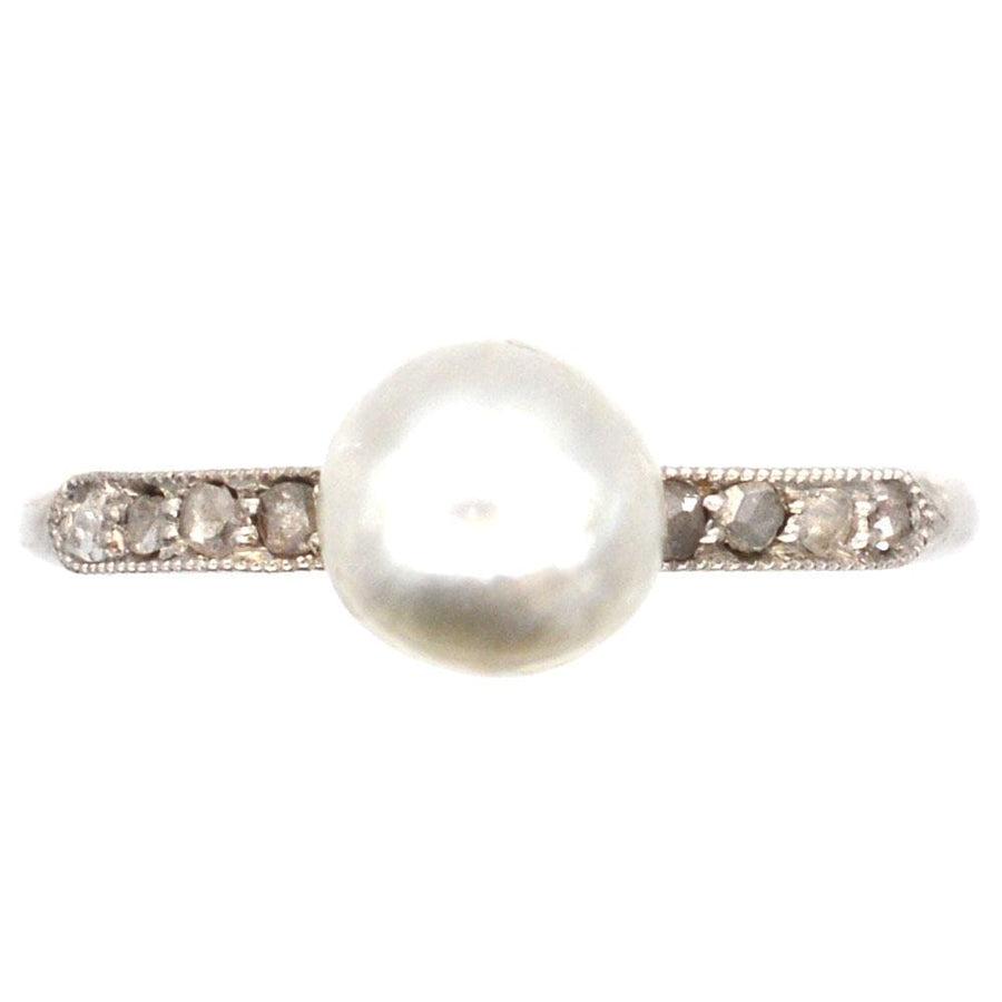 Edwardian 18ct white gold and platinum ring featuring a large natural pearl and diamond shoulders, classic engagement style.