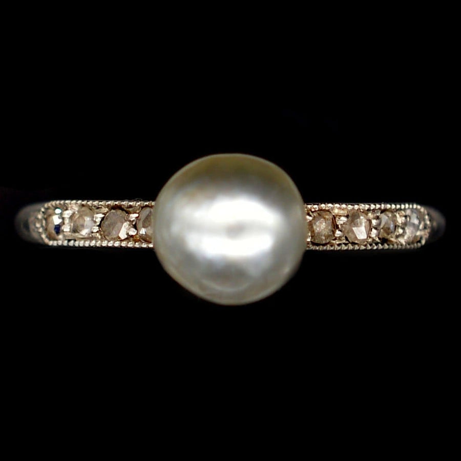 Edwardian 18ct white gold and platinum ring featuring a large natural pearl surrounded by sparkling diamonds.