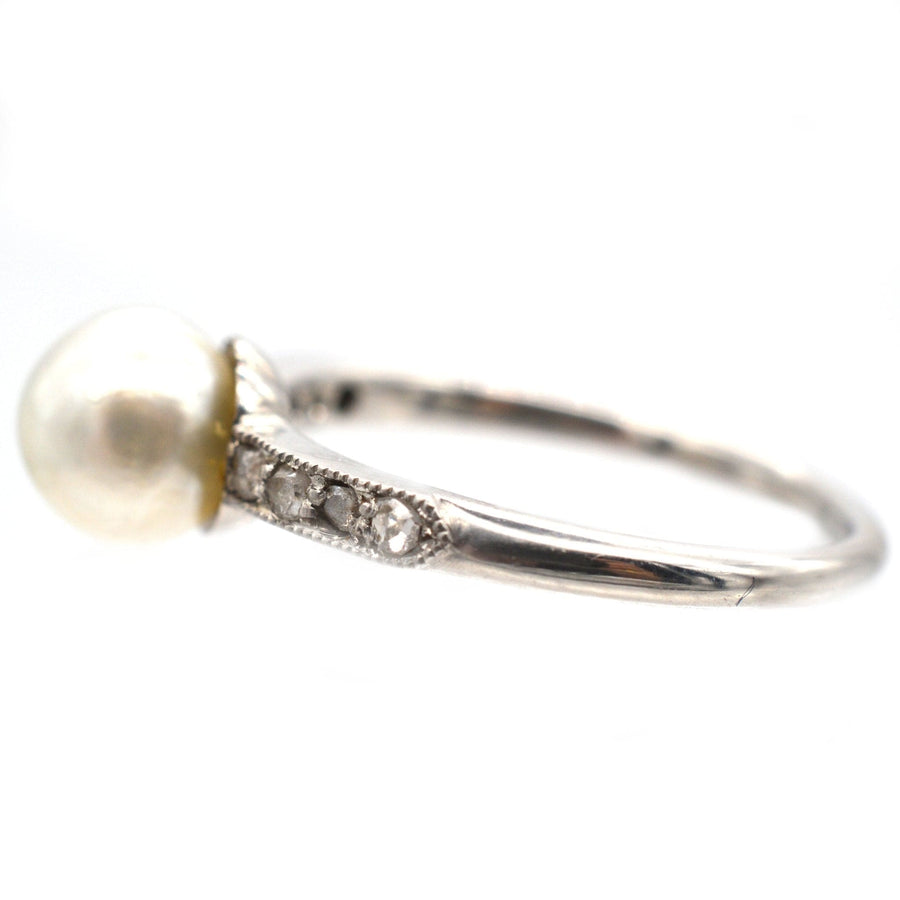 Edwardian 18ct white gold and platinum ring featuring a large natural pearl and diamond shoulders.