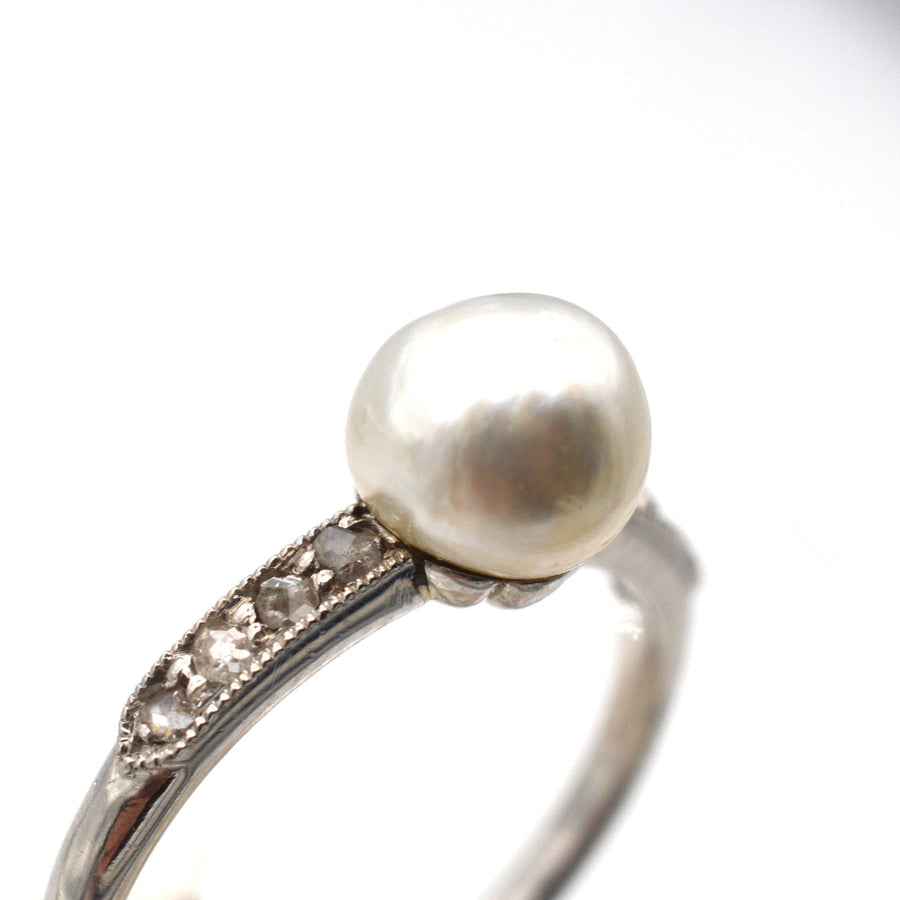 Edwardian style ring featuring a large natural pearl and diamond shoulders in white gold and platinum.