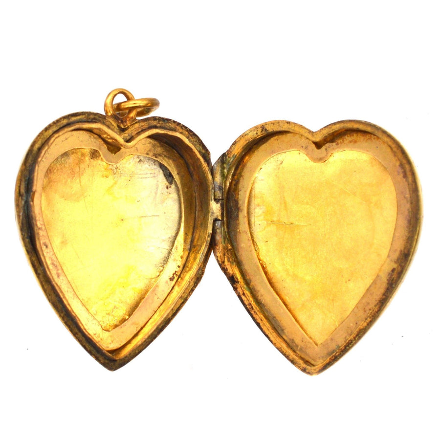 Inside view of a vintage 9ct gold heart locket pendant showing two empty heart-shaped compartments.