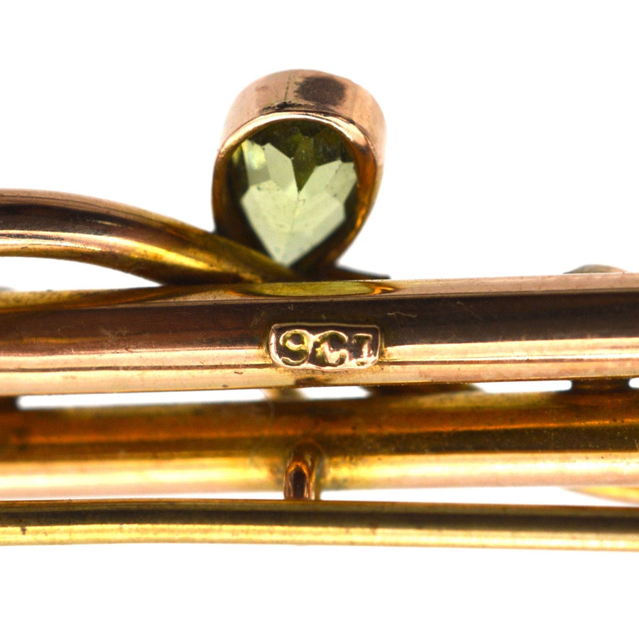 Close-up of Edwardian 9ct gold bar brooch showcasing a pear shape peridot and hallmark.
