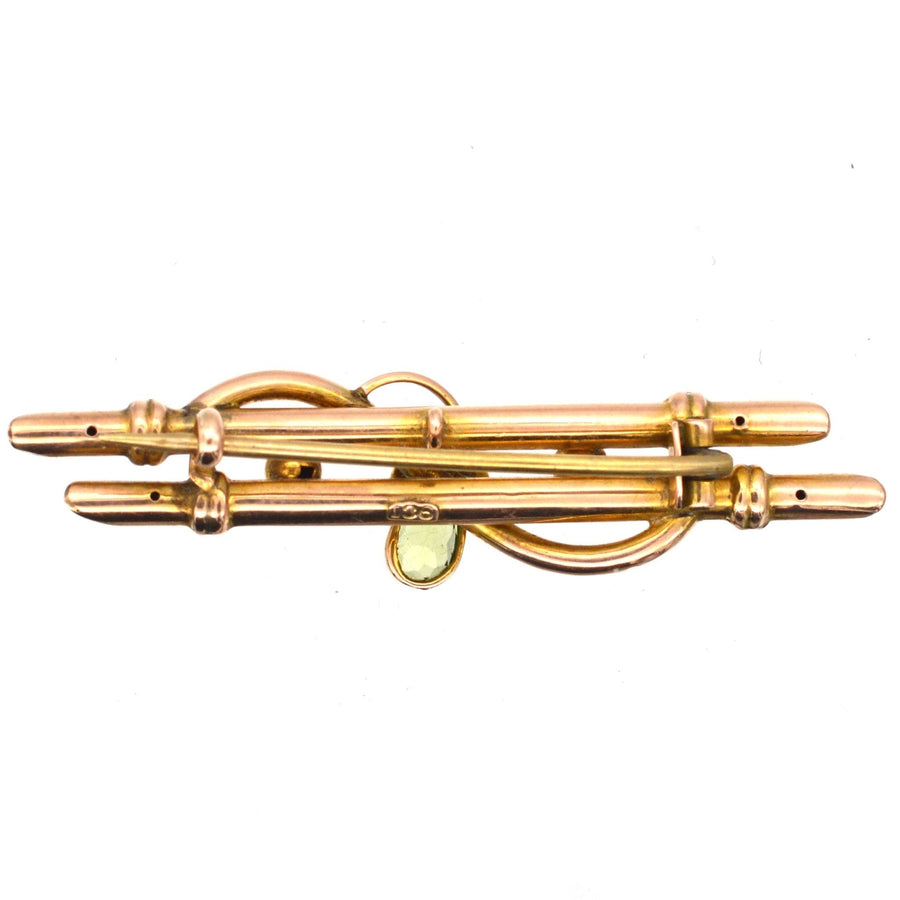 Edwardian 9ct gold bar brooch featuring flower motif with peridot and seed pearls, circa 1900-1910.