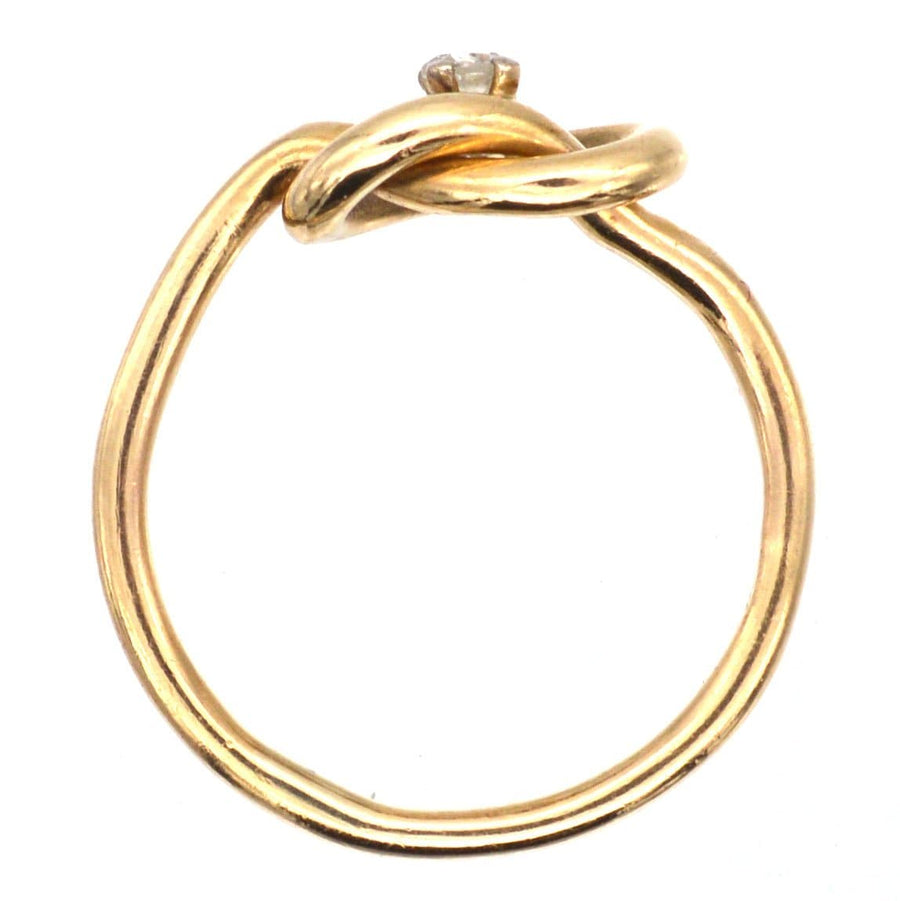 Elegant Edwardian 9ct gold ring with lover's knot design and center diamond, symbolizing infinite love.