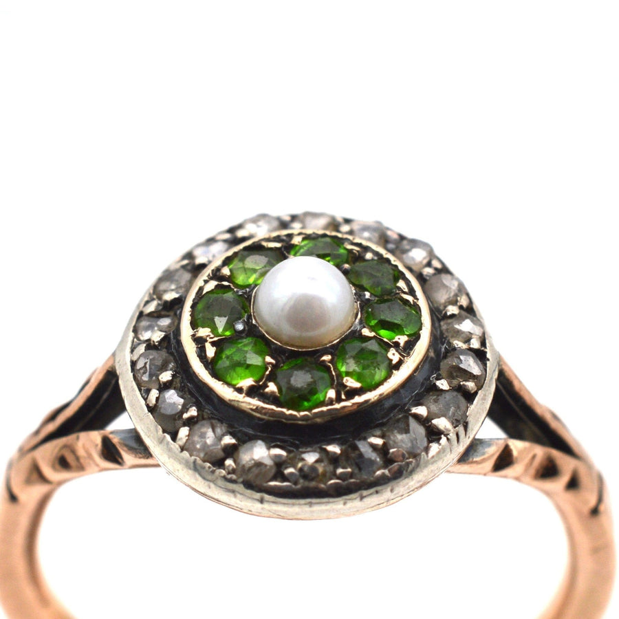 Edwardian 9ct gold target ring with green garnets, diamond halo, and natural pearl centerpiece.