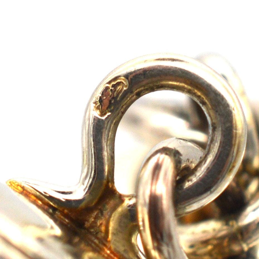 Close-up of vintage cufflink mechanism, showcasing intricate design and craftsmanship in gold and silver.