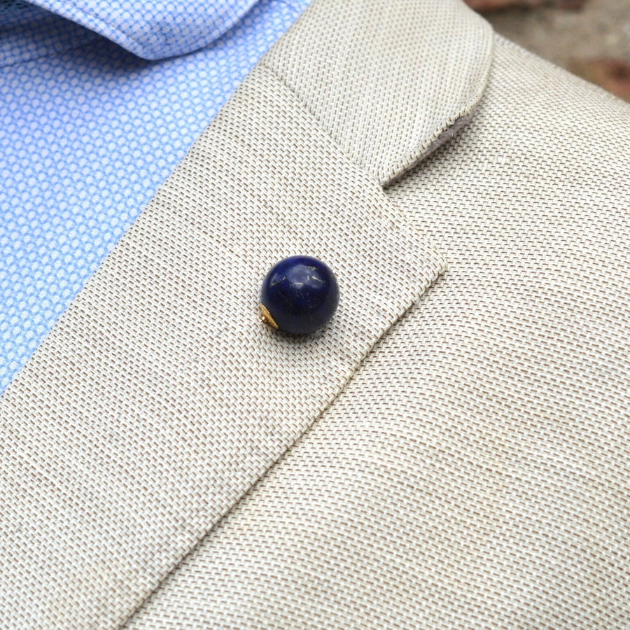 Large Victorian 18ct gold lapis lazuli sphere tie pin worn on a beige blazer lapel.