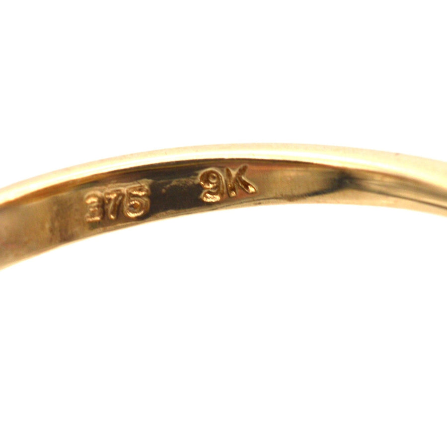 Close-up of gold ring interior displaying 375 hallmark indicating 9ct gold quality.