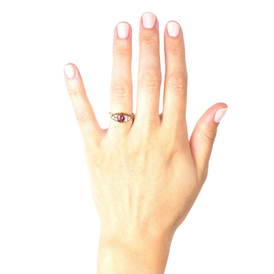 Late Victorian 18ct gold ring featuring pink tourmaline and diamonds, worn on a hand with light pink nails.