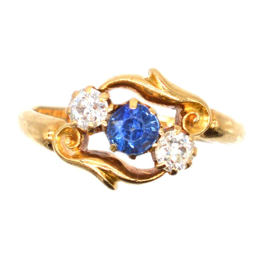 Late Victorian 18ct gold crossover ring featuring sapphire and diamond stones, intricately carved design.