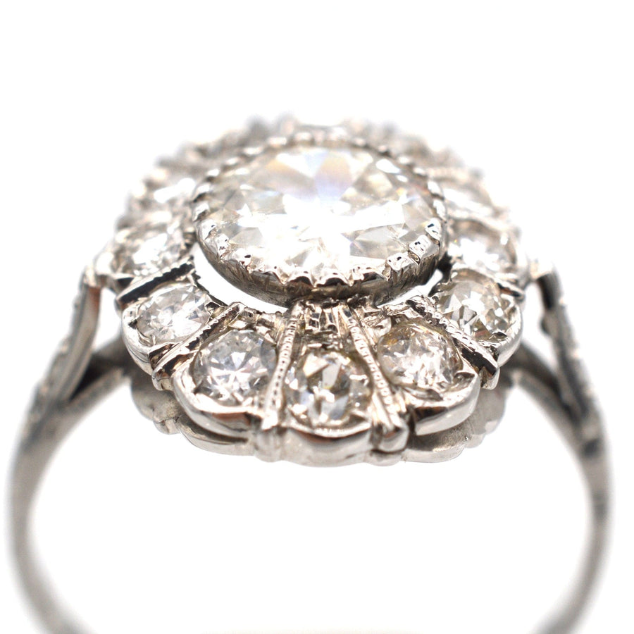 Mid Century 18ct white gold oval diamond cluster ring featuring a 1 carat center stone and sparkling surrounding diamonds.