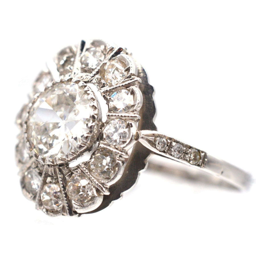 Mid Century 18ct white gold oval diamond cluster ring featuring a 1 carat center diamond, circa 1960.