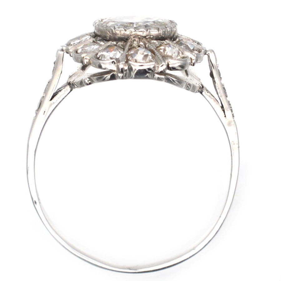 18ct white gold oval diamond cluster ring featuring a 1 carat center diamond, perfect for engagement or special occasions.