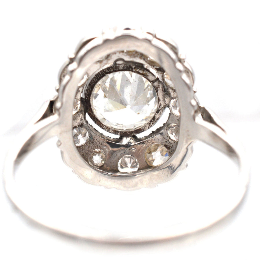Mid Century 18ct white gold oval diamond cluster ring featuring a 1 carat center diamond and sparkling smaller diamonds.
