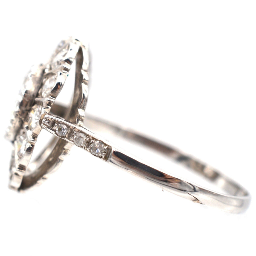 Mid Century 18ct white gold oval diamond cluster ring featuring a 1 carat central diamond and sparkling side diamonds.