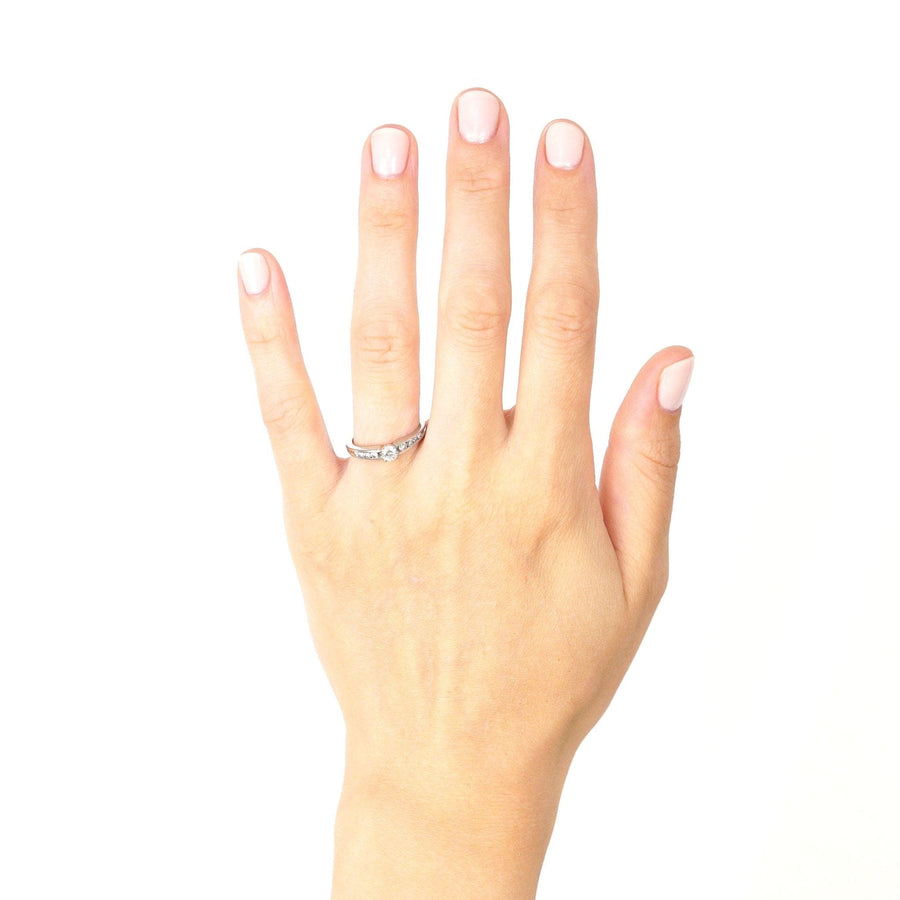 Modern 18ct white gold solitaire ring with diamond shoulders on a hand.