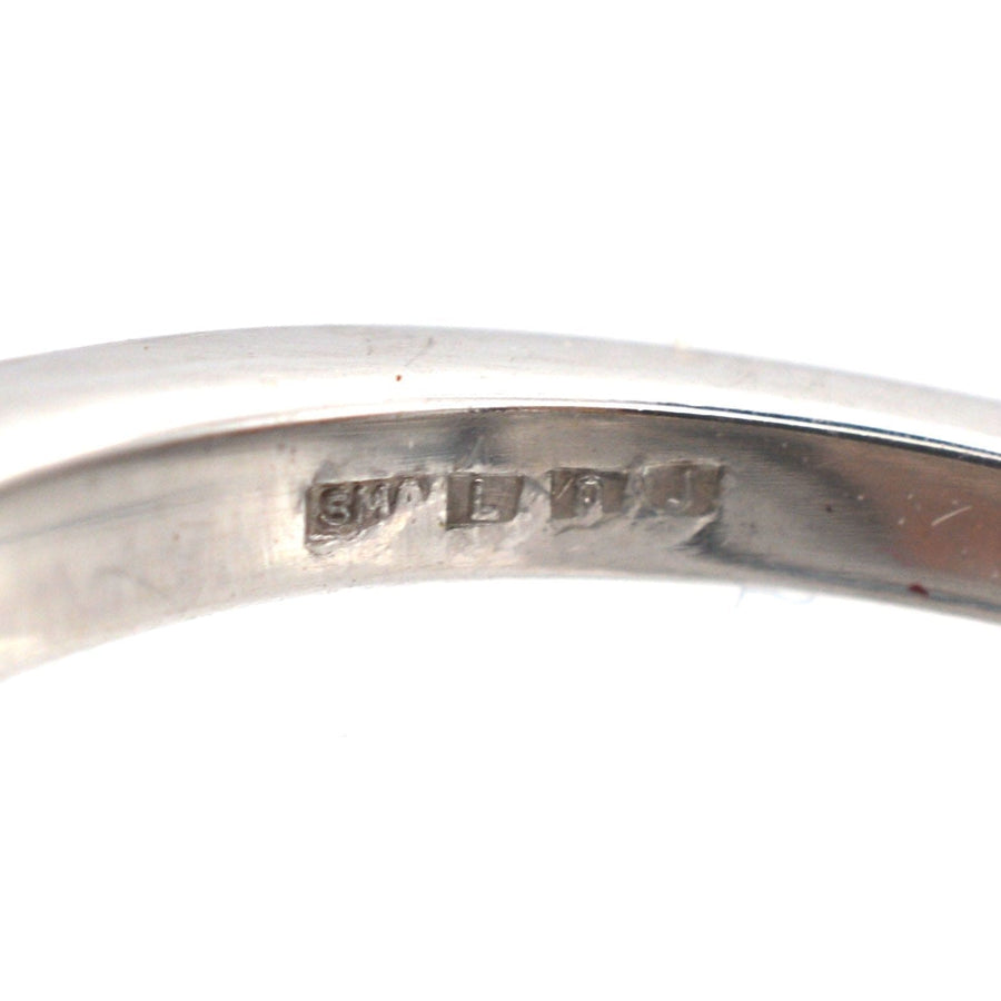 Close-up of the inner band of an 18ct white gold ring with metal hallmarks and markings.