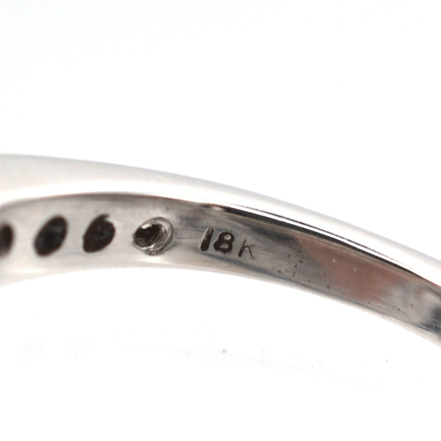 Close-up of the inner band of an 18ct white gold ring, featuring a hallmark for authenticity.