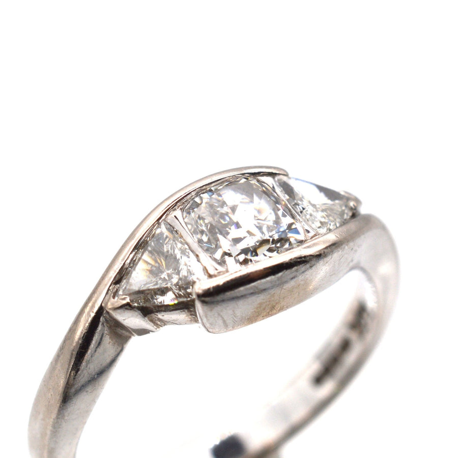 Modern 18ct white gold three stone diamond ring featuring GIA certified cushion cut diamond and trillion cut side stones.