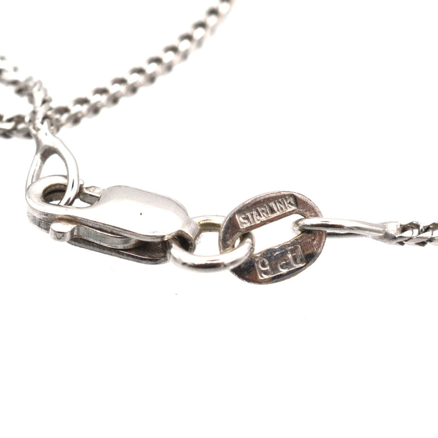 Close-up of a 9ct white gold necklace clasp with Starlink engravings.