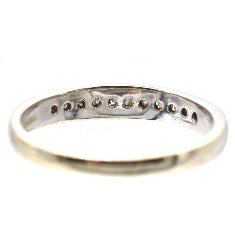 9ct white gold diamond half eternity ring with channel setting showcasing 0.25 carats of brilliant cut diamonds.