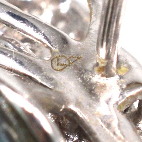 Close-up of the silver earring setting showing intricate details and hallmark for the diamond bow and black pearl earrings.