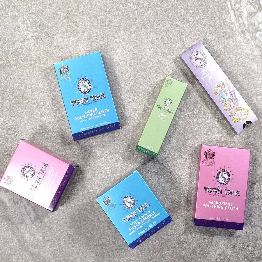 Assorted Town Talk polishing cloths in colorful packaging on a textured surface.