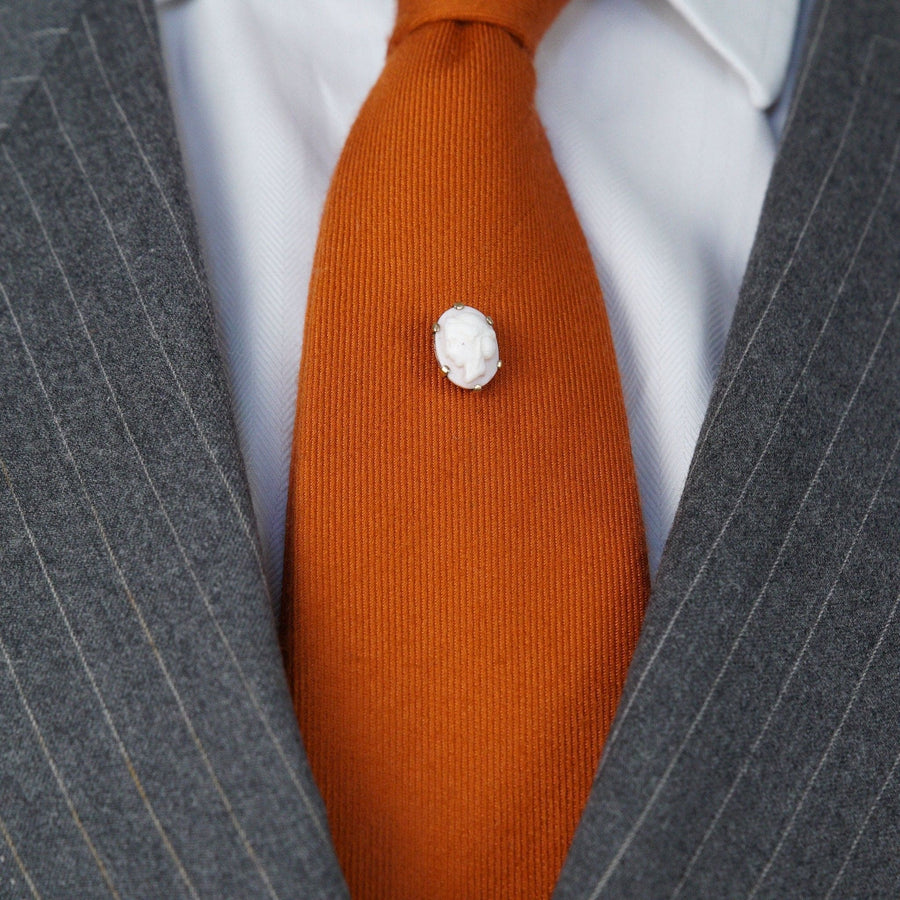 Victorian 9ct gold tie pin featuring a pink conch shell cameo of a Roman goddess accessory on an orange tie.