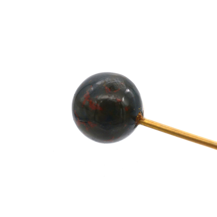 Victorian gold tie pin featuring a spherical bloodstone with deep red spots, symbolizing bravery and vitality.