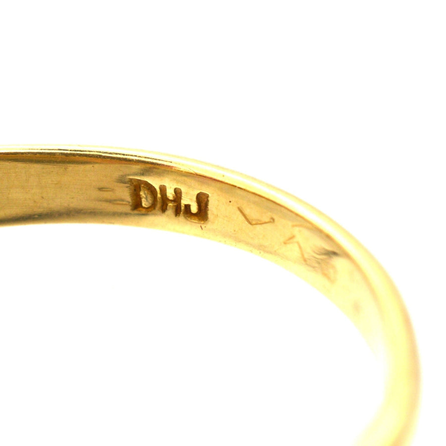 Close-up of a Victorian-style 18ct gold ring showcasing the DHJ hallmark engravings.