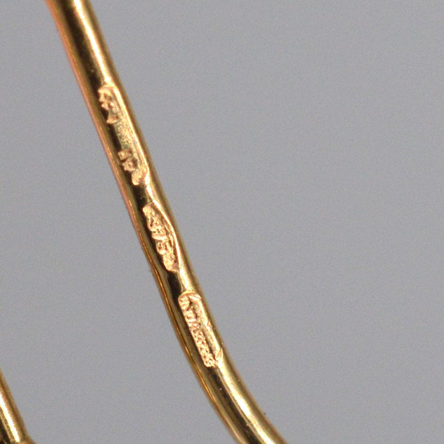 Nahaufnahme von Punzierungen auf Ohrringen aus 9-karätigem Gold aus den 1940er Jahren, die authentische Vintage-Details zeigen.
