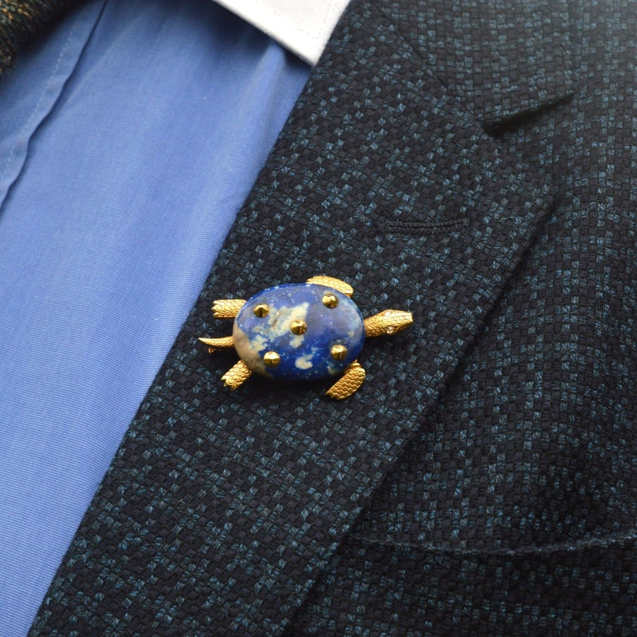 Cartier-Schildkrötenbrosche aus 18-karätigem Gold der 1950er Jahre mit Lapislazuli-Körper und Diamantaugen, getragen an einem Anzug.