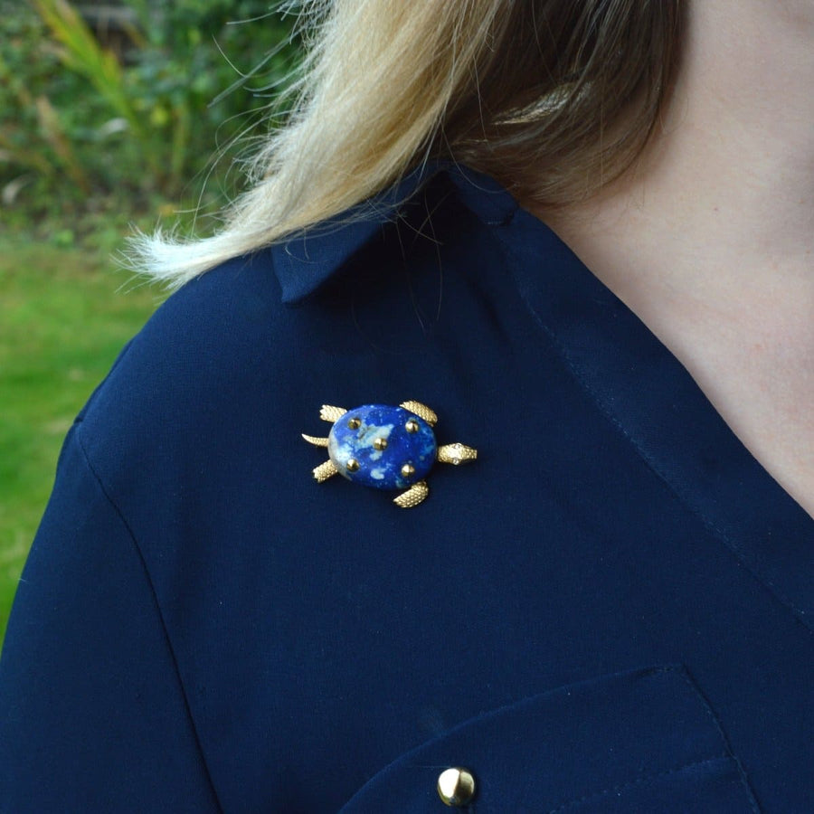 1950er Cartier Schildkrötenbrosche aus 18 Karat Gold mit Lapislazuli und Diamantaugen, getragen auf einem marinefarbenen Hemd
