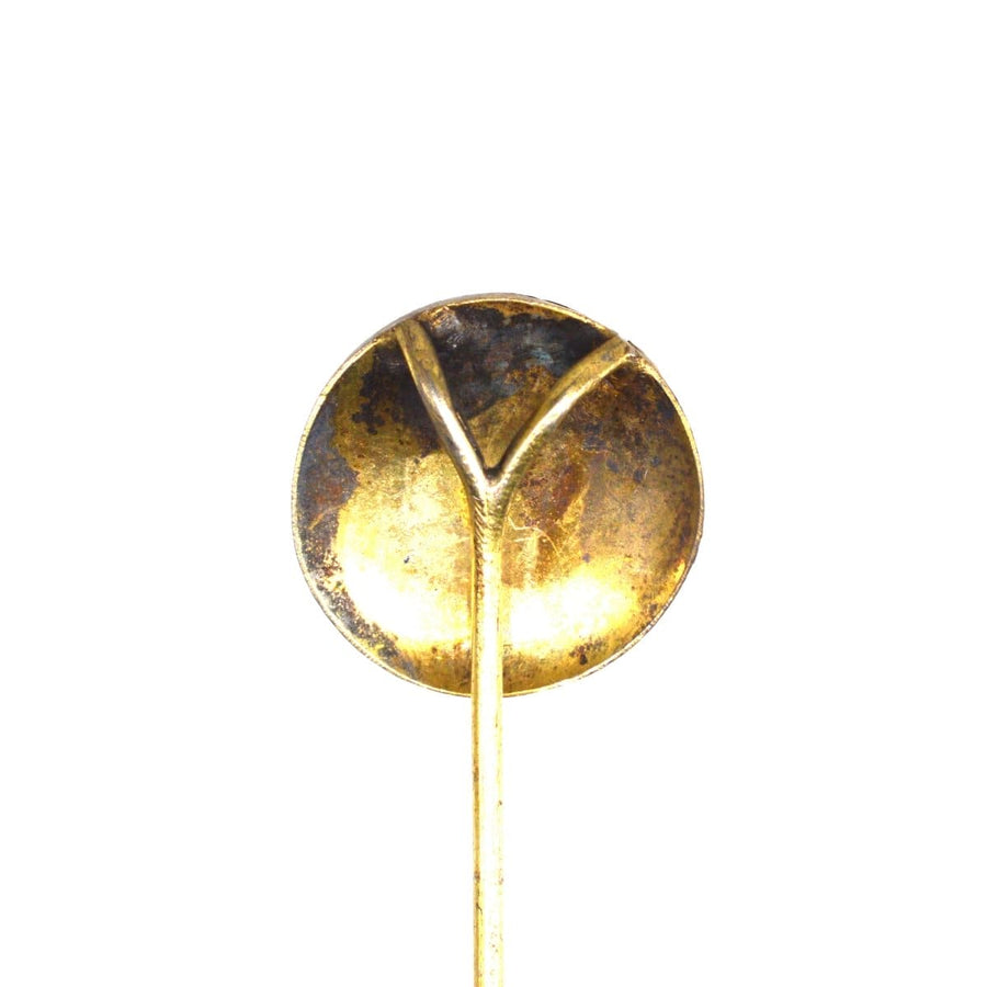 Goldfarbener Vintage-Löffel mit runder Schale und zartem Y-Muster am Stiel.