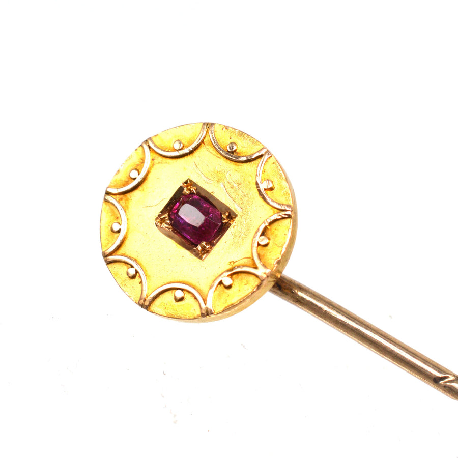 Victorian 15ct gold circle tie pin featuring a central ruby and intricate gold swirls, perfect for silk ties.