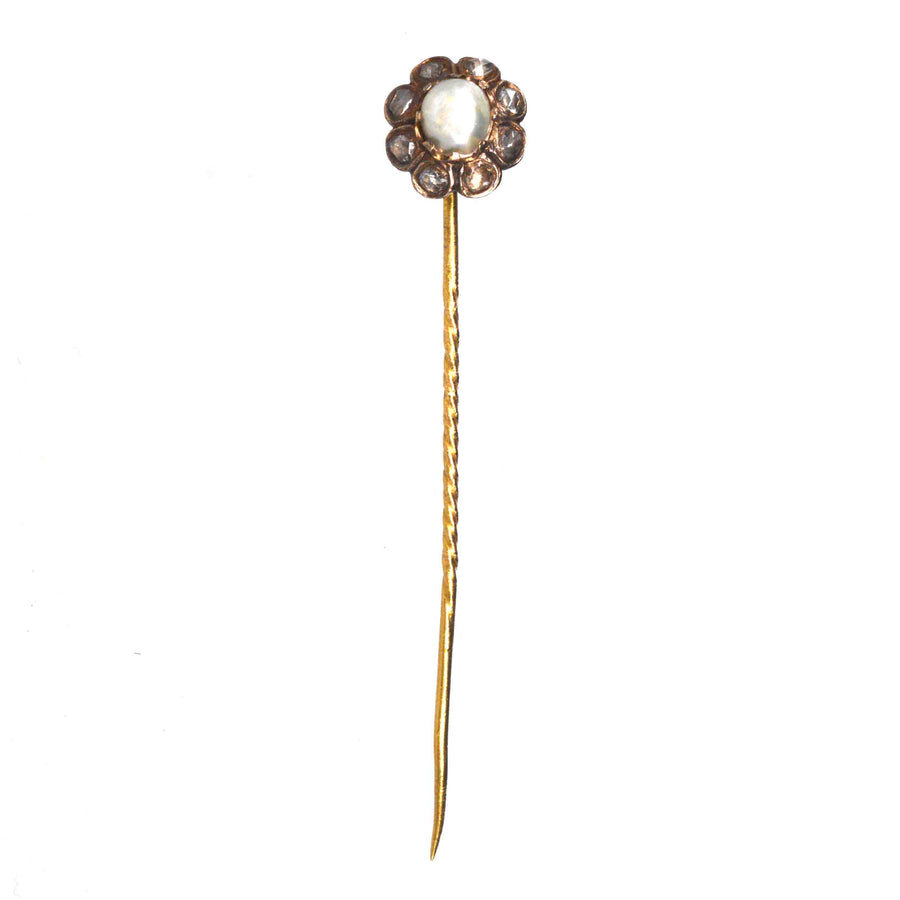 19th century 18ct gold tie pin featuring a natural pearl surrounded by rose cut diamonds in a floral design.